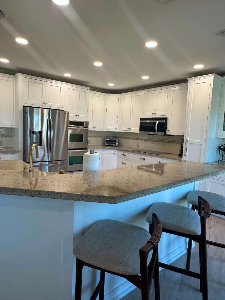 Immaculate kitchen with clean counters, white cabinetry, and stainless appliances